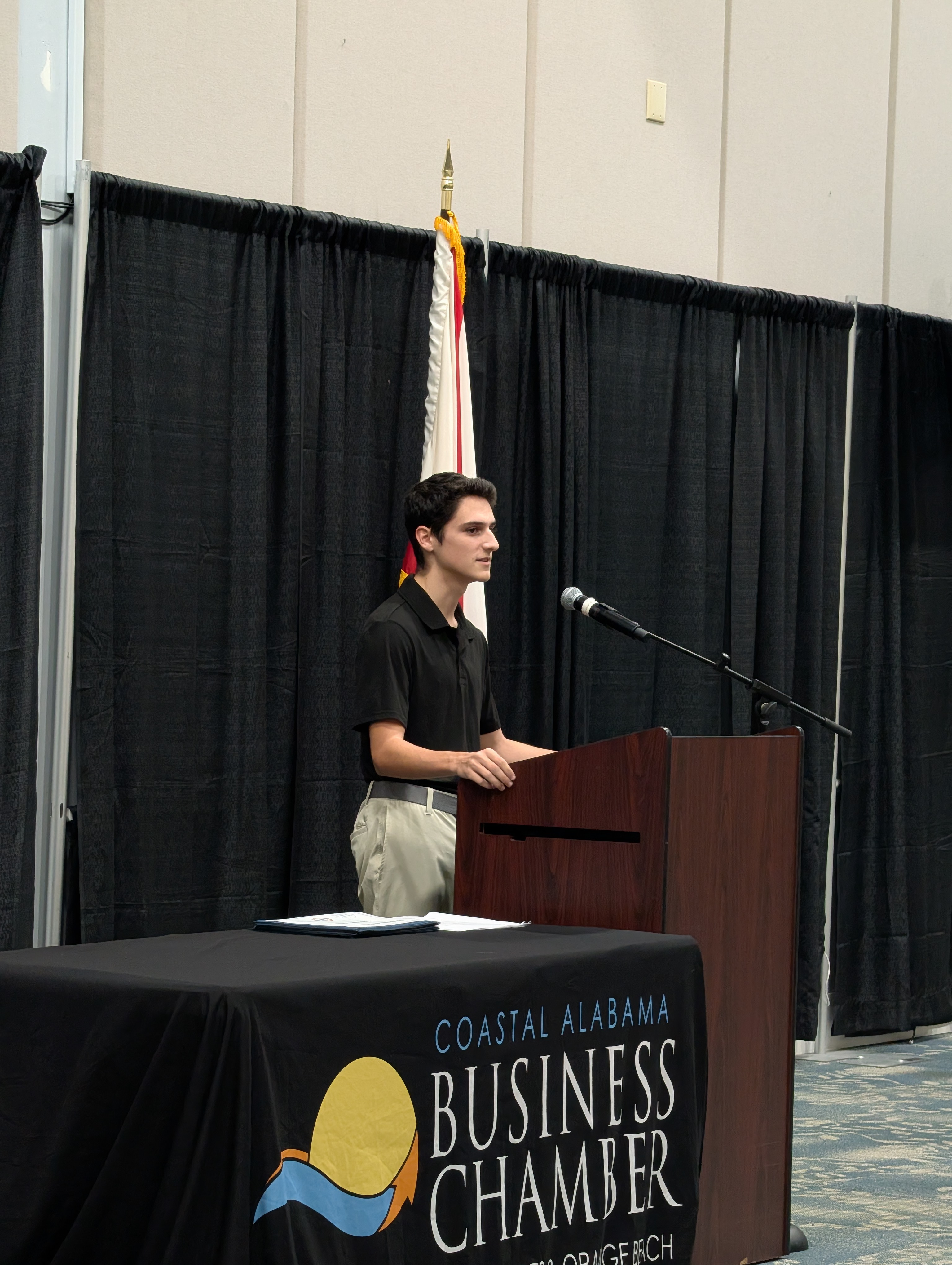 Student speaking in front of Coastal Alabama Business Chamber